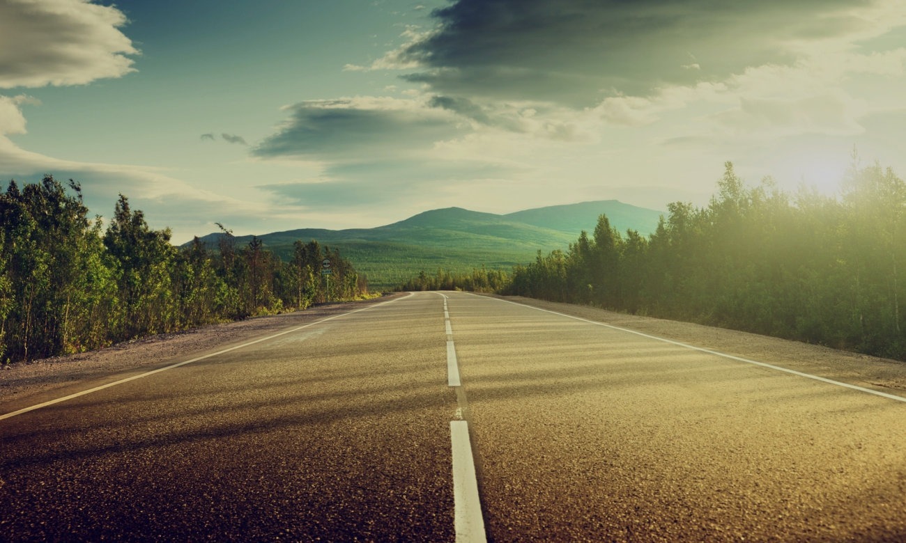an open road headed toward the mountains