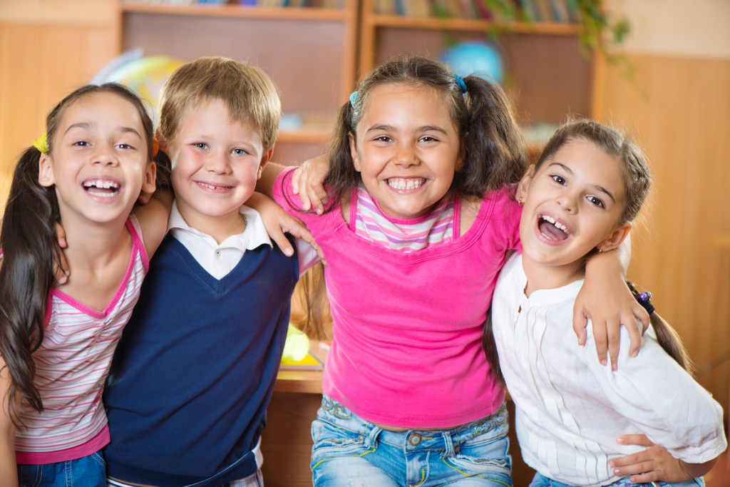 four school children posing and smiling