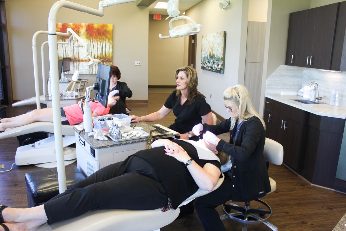 Dillehay assistants working on a patient's teeth